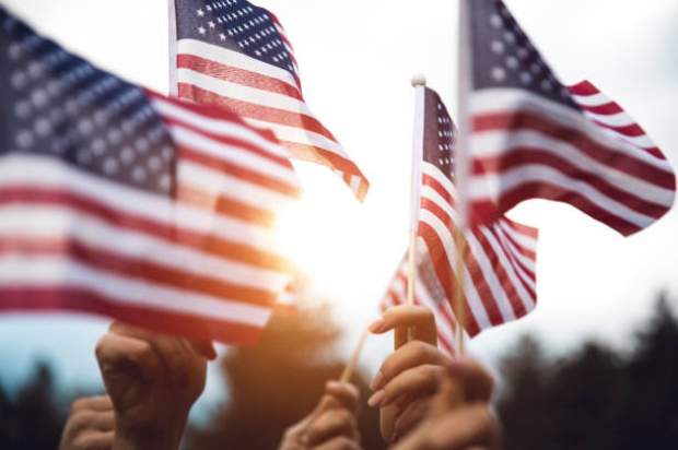 group of people raising American flags above their heads